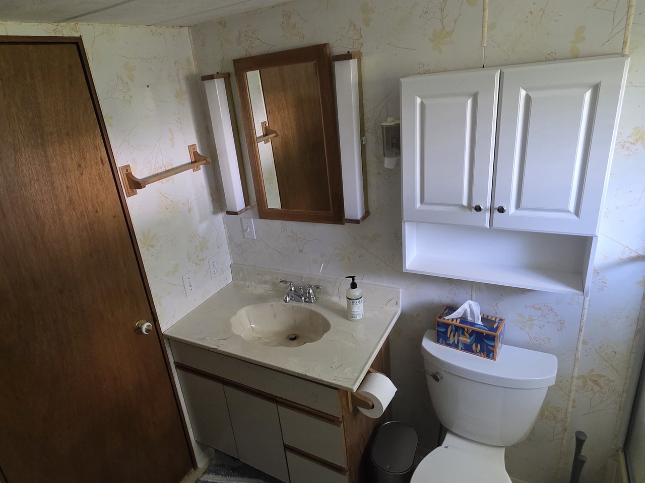 The full bathroom with vanity and storage