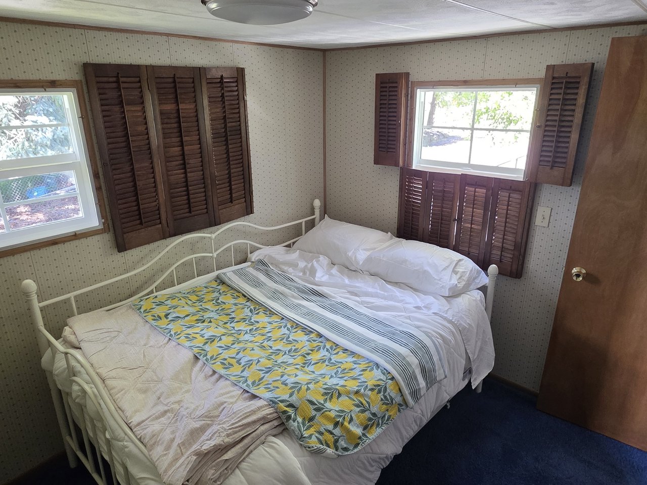 Second bedroom with a full bed and wood shutters