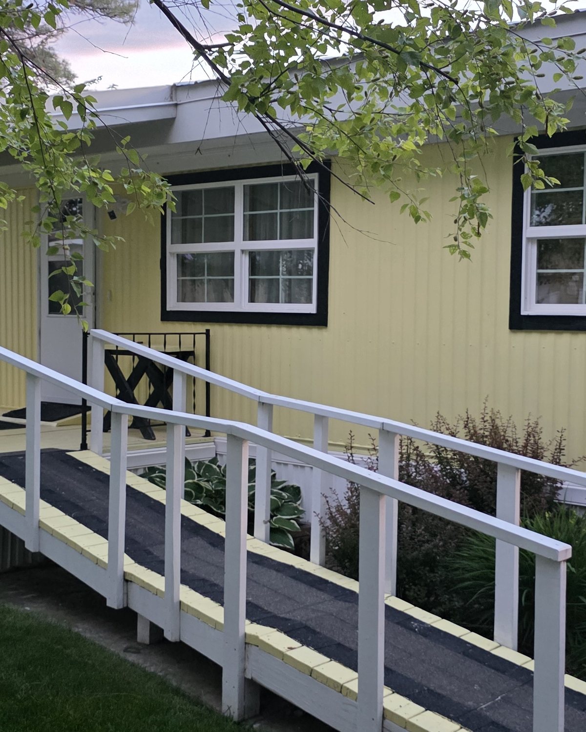 Golden-hour view of the ramped front entry and porch